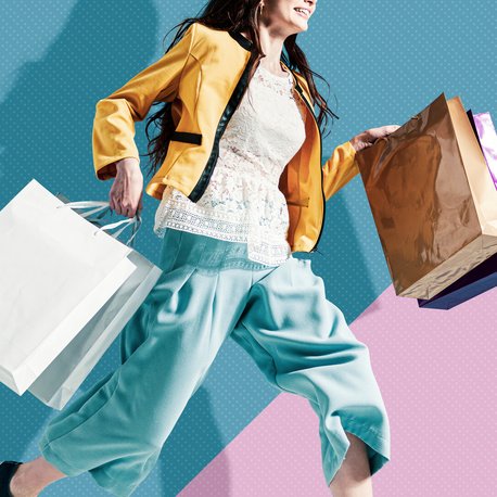 Cheerful stylish woman running to get the latest offers and carrying shopping bags, blank copy space
